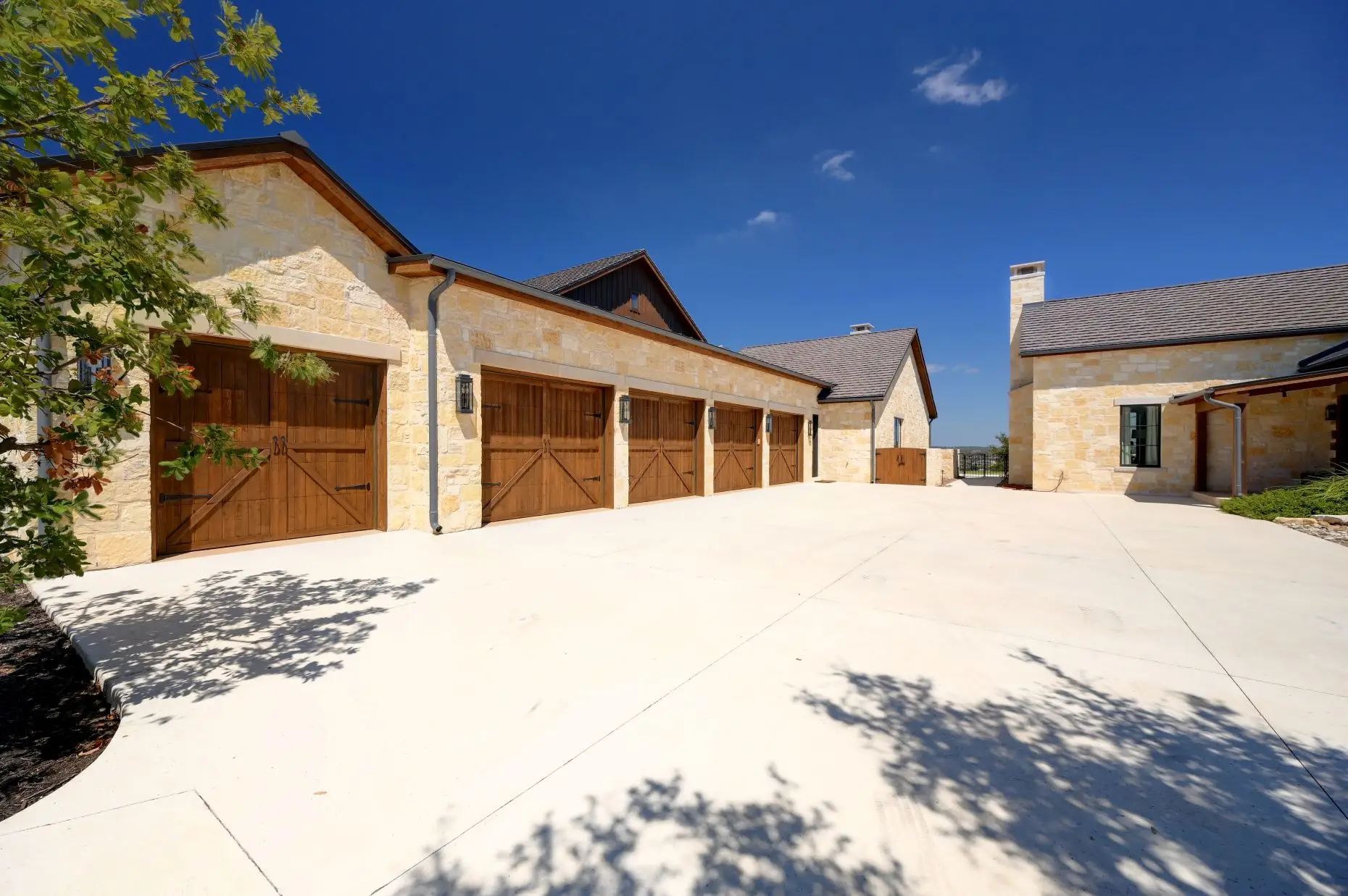 Aerial view of a stone ranch home set around a fountain courtyard, with clipped lawns and open country beyond.