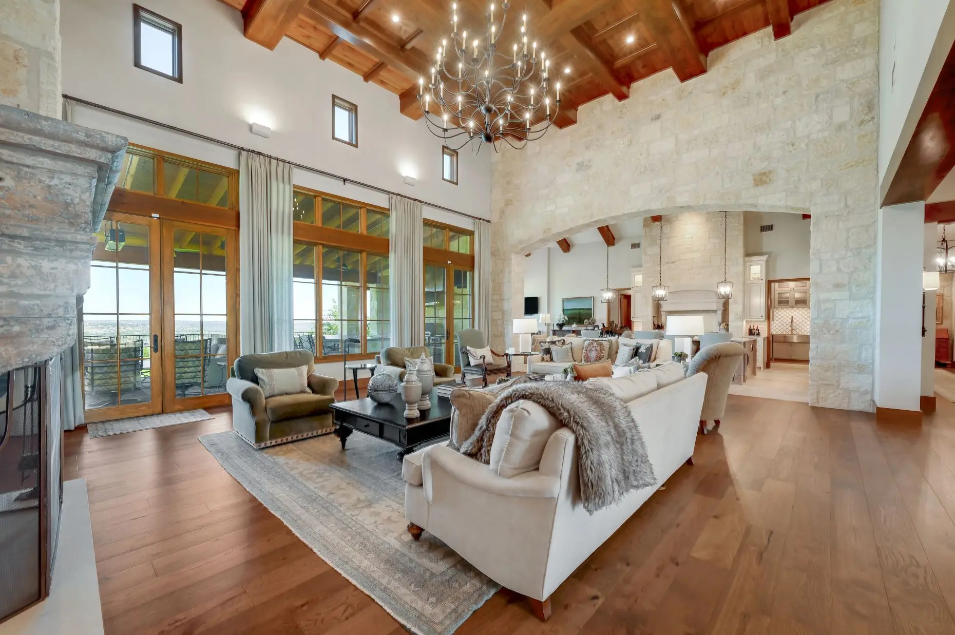 Aerial view of a stone ranch home set around a fountain courtyard, with clipped lawns and open country beyond.