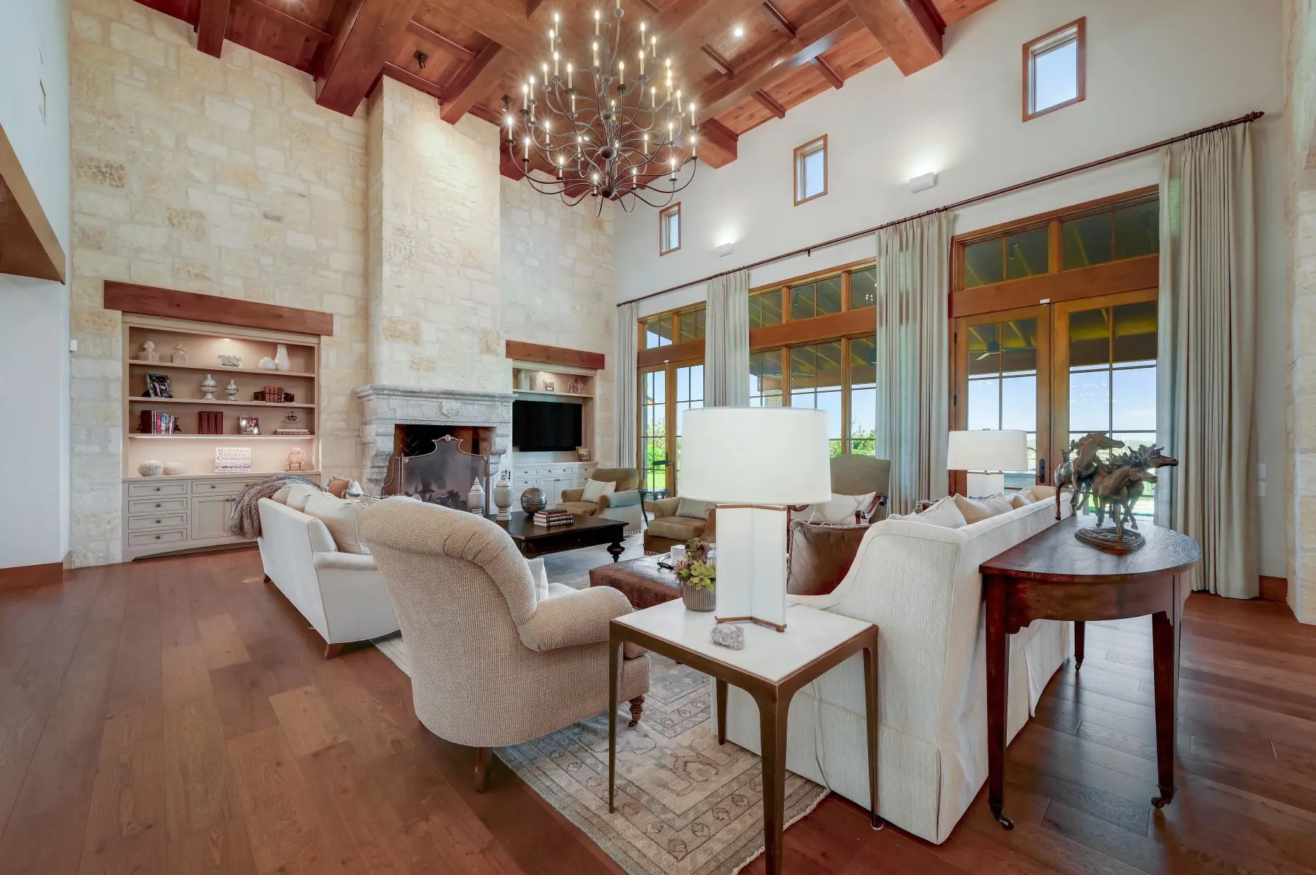 Aerial view of a stone ranch home set around a fountain courtyard, with clipped lawns and open country beyond.