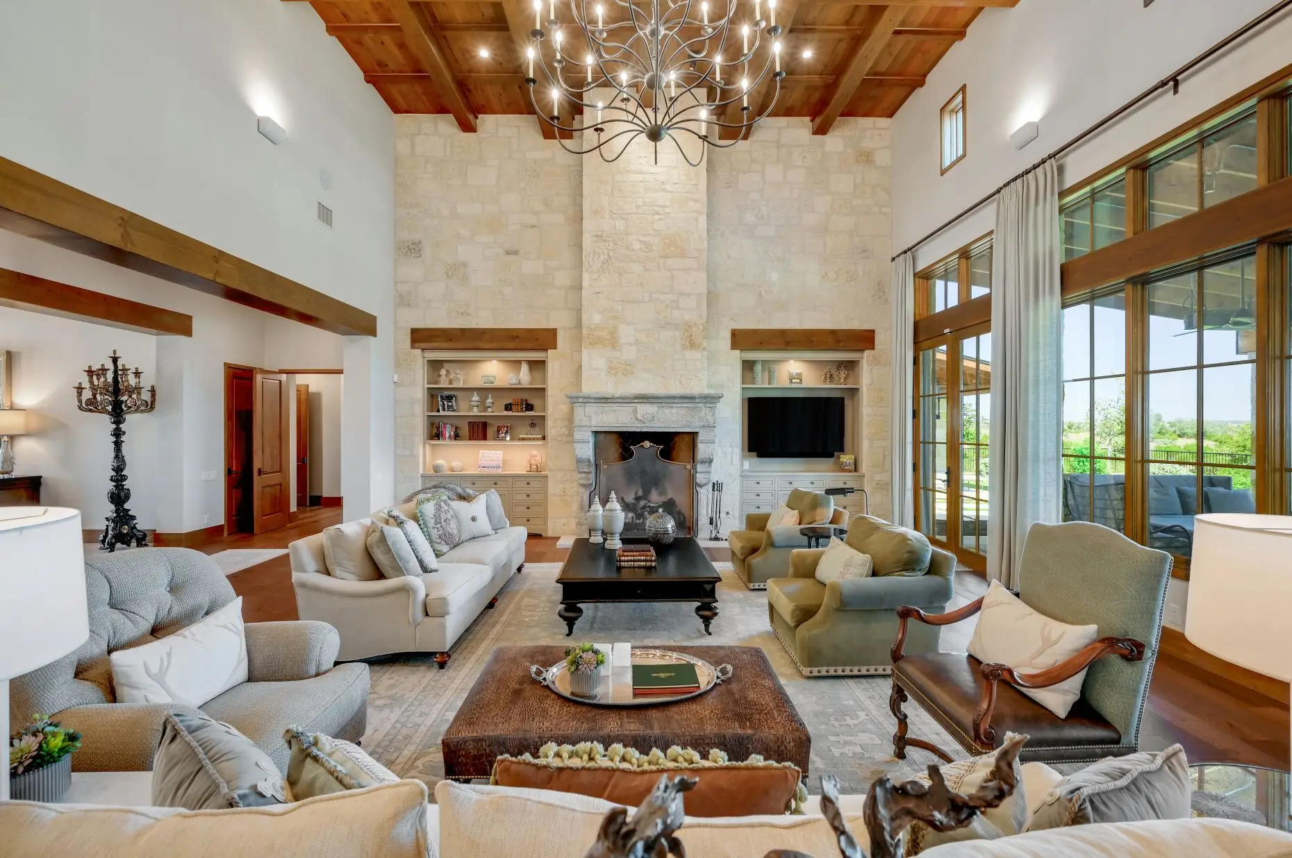 Aerial view of a stone ranch home set around a fountain courtyard, with clipped lawns and open country beyond.