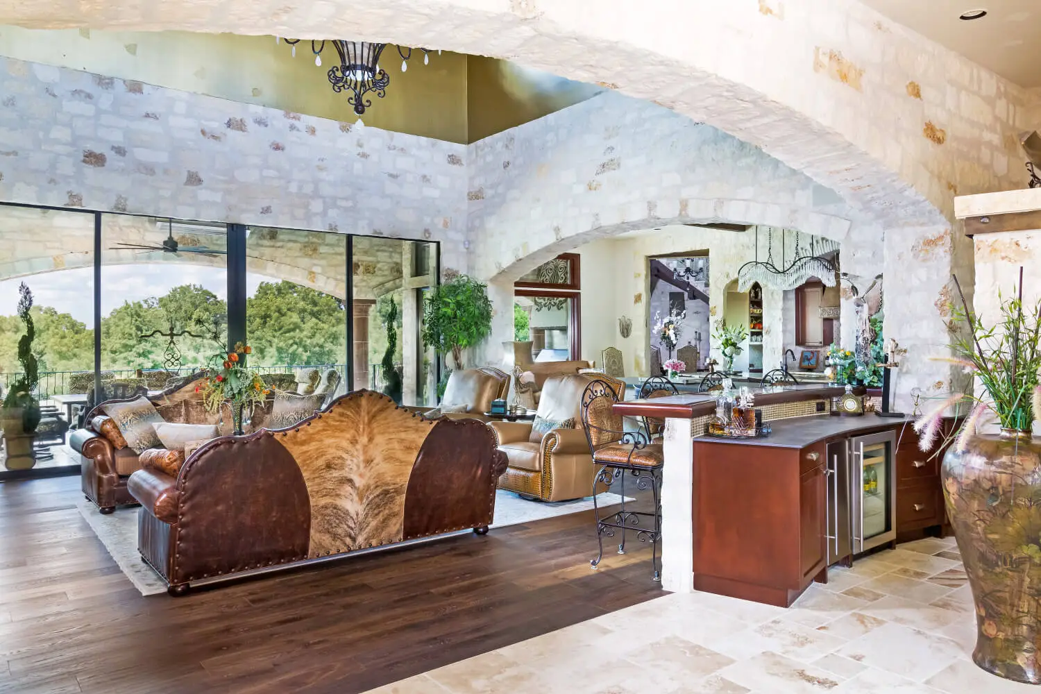 Tuscan-style villa with tile roofs and a stone terrace, seen across still water from the far bank.