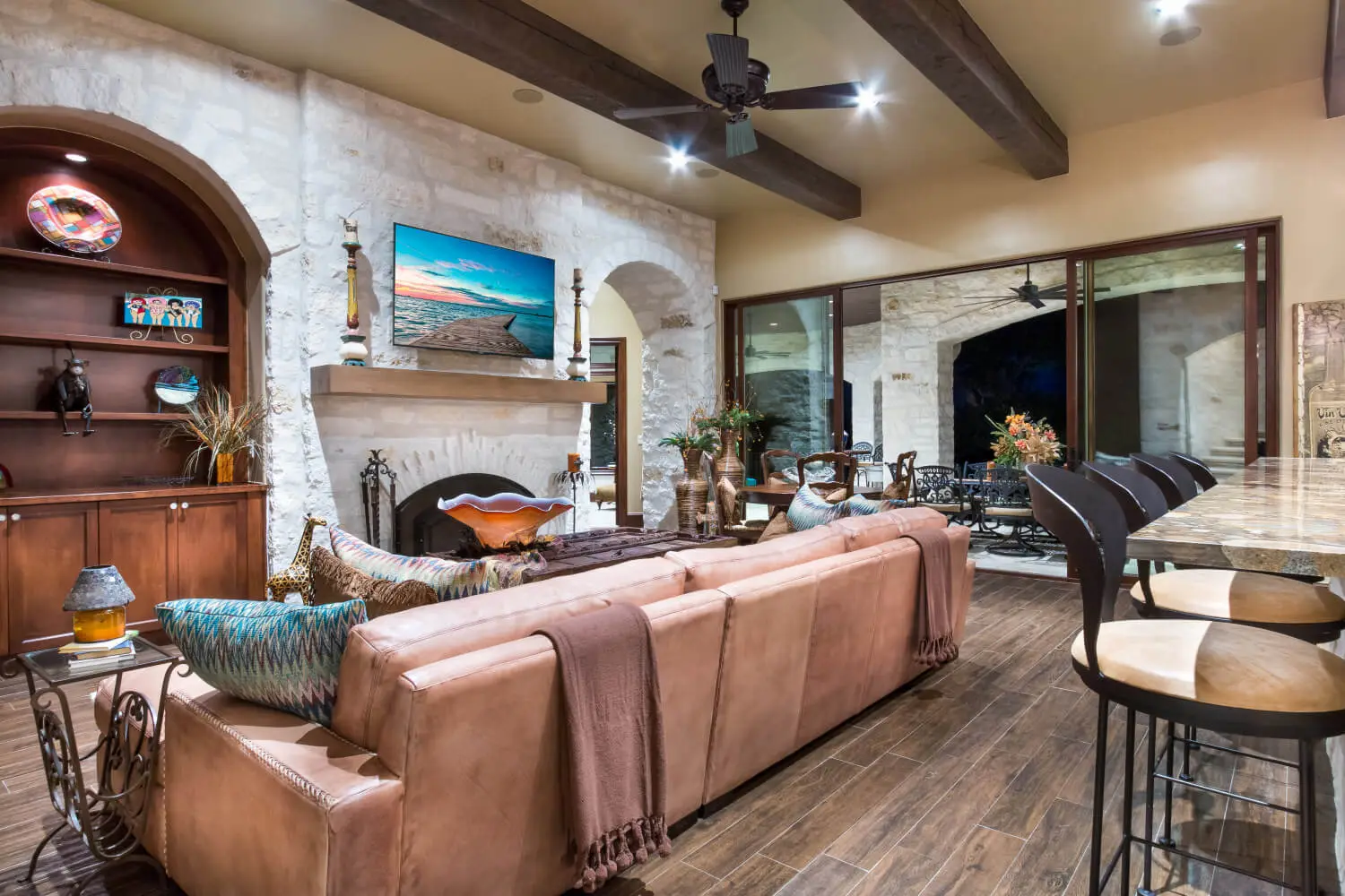 Tuscan-style villa with tile roofs and a stone terrace, seen across still water from the far bank.