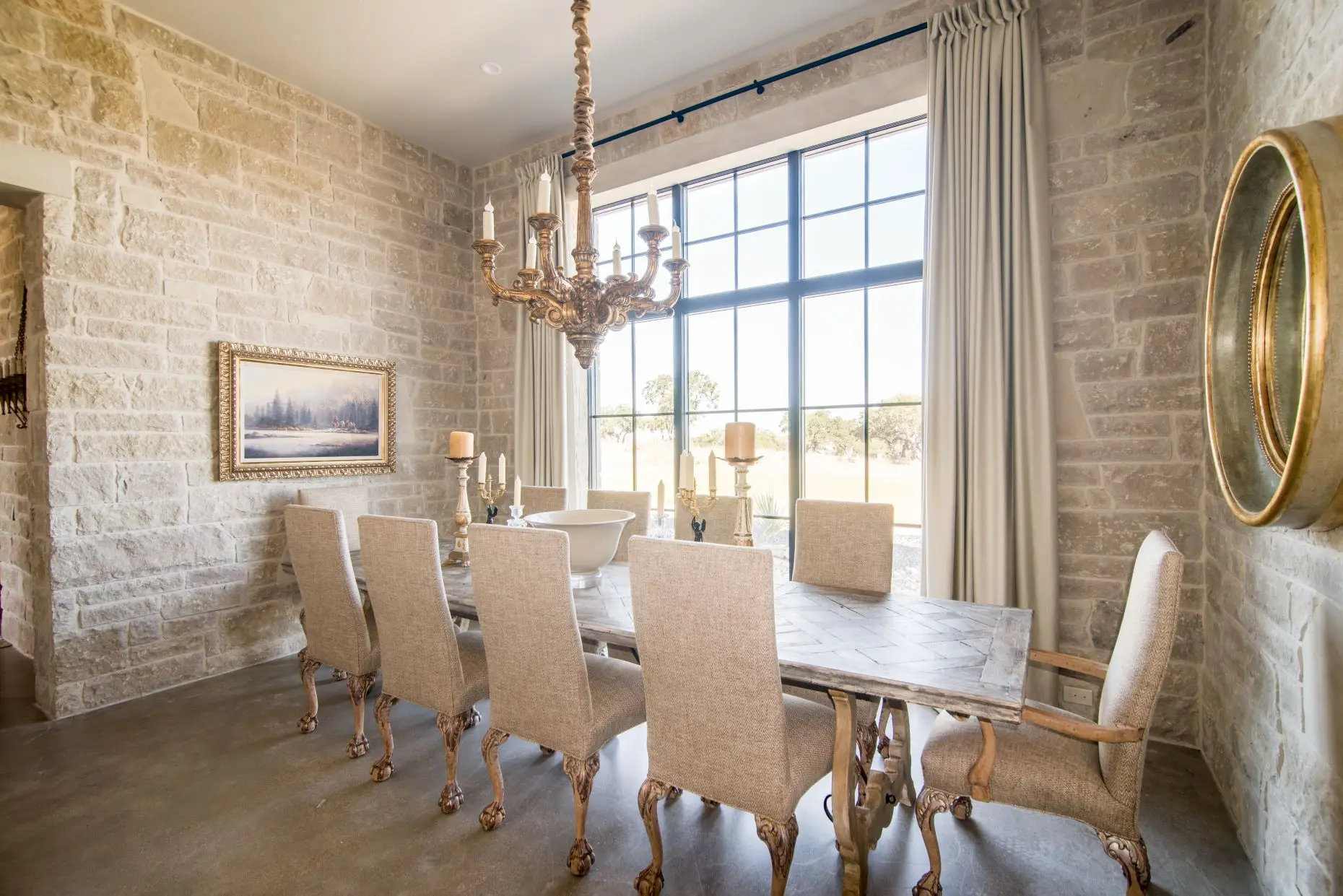 Stone loggia on timber posts running along the rear of the home, above a flagstone terrace set in gravel.