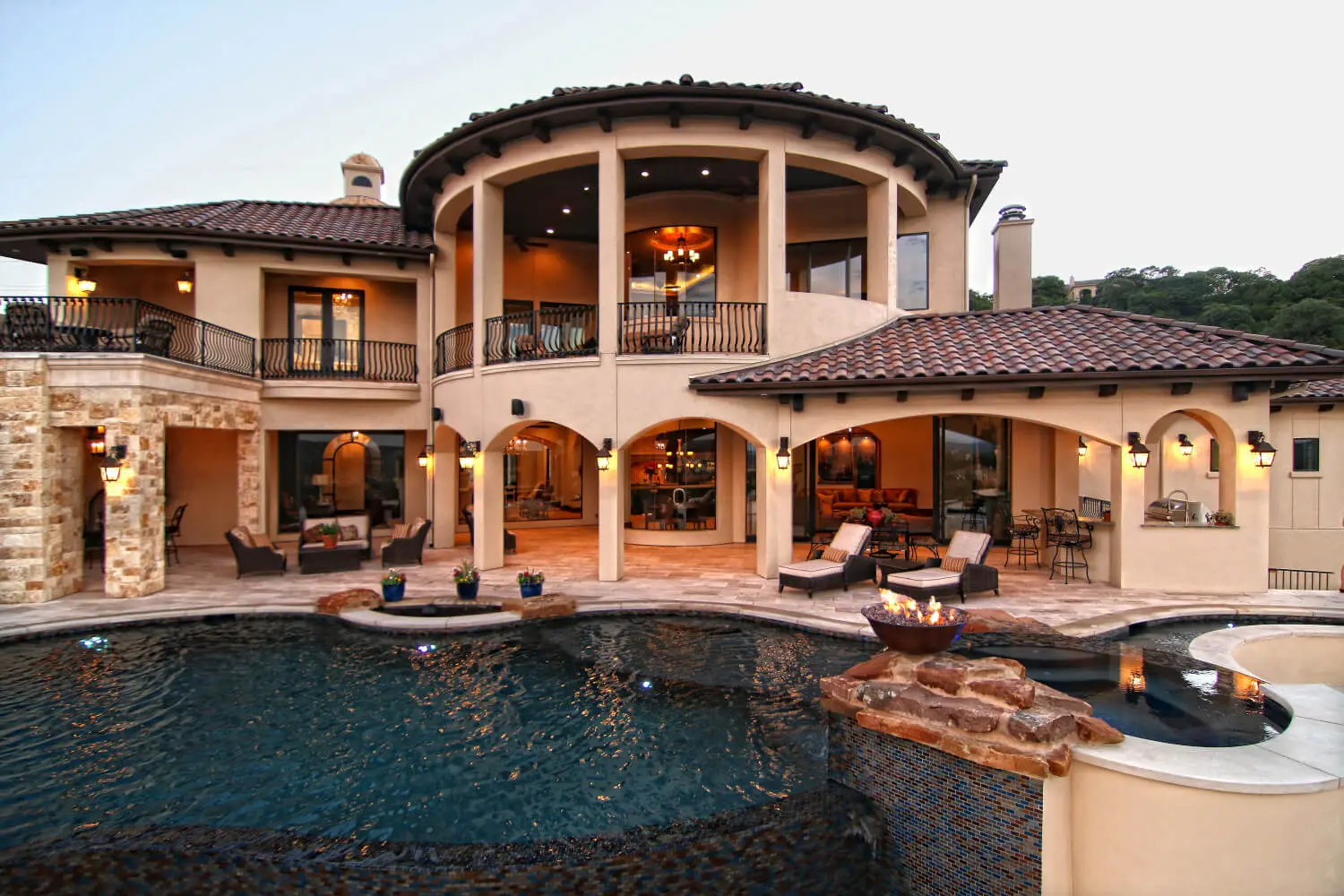 Rear elevation with a curved two-storey loggia and balcony, above a pool and spa.